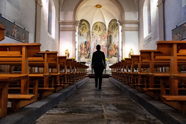 Personne qui entre dans l'Eglise de Saillon