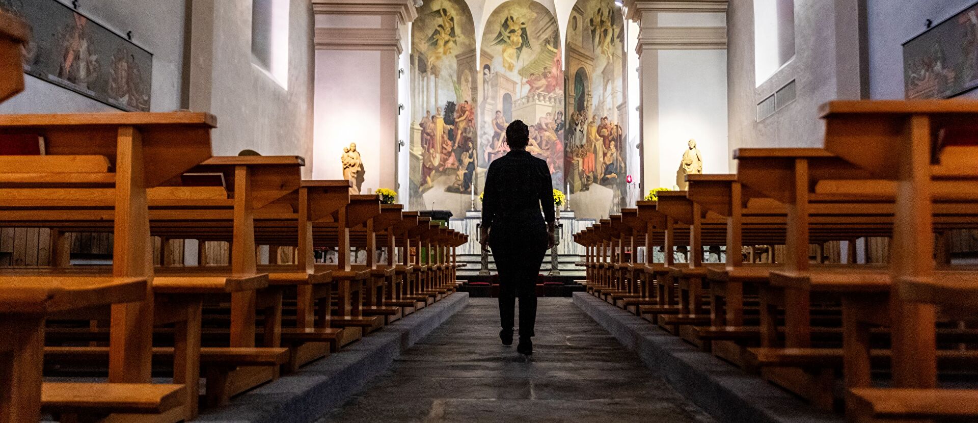 Personne qui entre dans l'église de Saillon