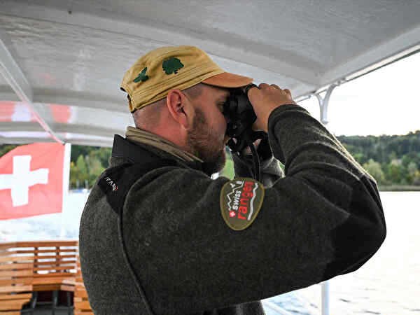 Mann mit Fernglas auf Schiff