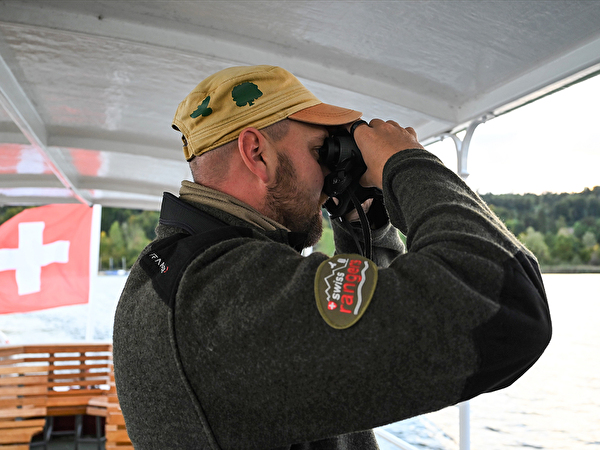 Mann mit Fernglas auf Schiff