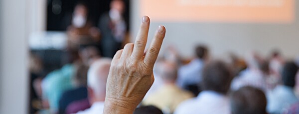 Hand zur Abstimmung hochgestreckt