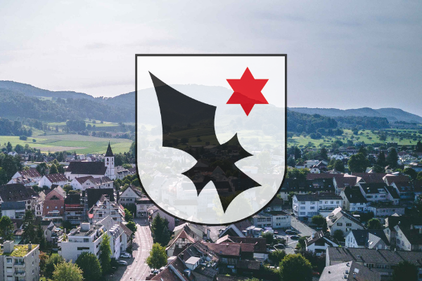 Aescher Wappen mit dem Dorf im Hintergrund