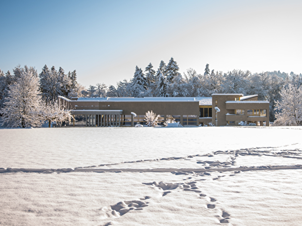 Das Schulhaus und der Sportplatz liegen unter einer weissen Schneedecke.