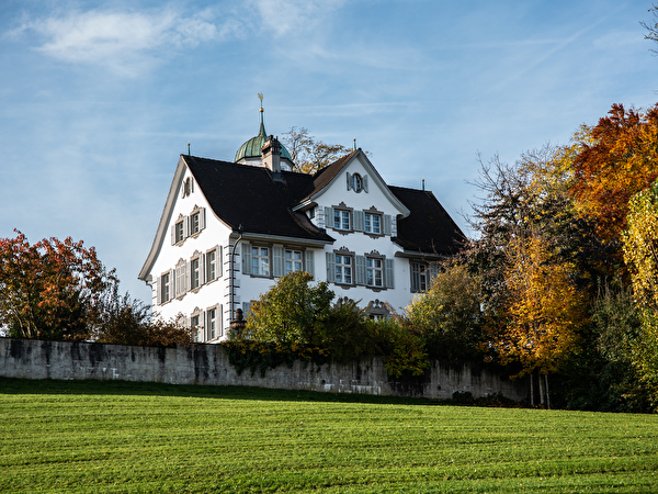 Das Schloss grosser Hahnberg umgeben von herbstlichen Bäumen in den Farben gelb und rot.