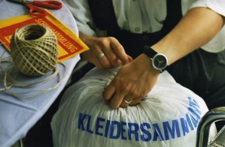 Frau bindet Kleidersammlungssack zu