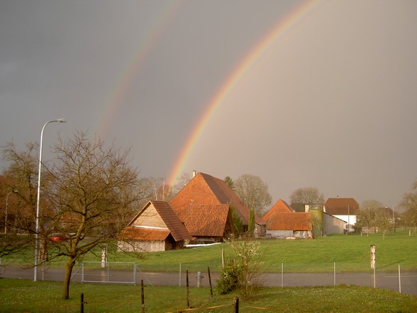 Regenbogen über den Bauernhäusern