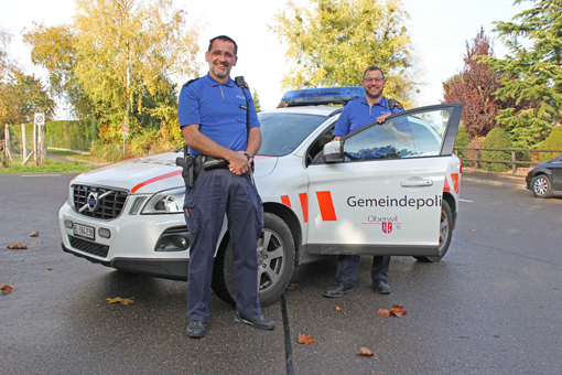 Die Gemeindepolizisten stehen vor dem neuen Polizeiauto.