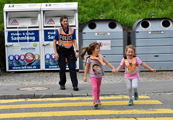 Zwei Kindergartenkinder überqueren die Alpsteinstrasse – angeleitet und beobachtet von Nadja Dietrich.