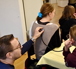 Bruno Klingler, Leiter Bildung Stiftung «Leben im Alter», übt mit zwei Schülerinnen den Umgang mit dem Stethoskop.