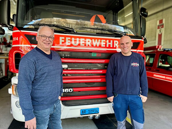 Beni Geel, Abteilungsleiter Technische Dienste, und Joe Gwerder, Gerätewart Feuerwehr, vor einem Tanklöschfahrzeug im Feuerwehrdepot.