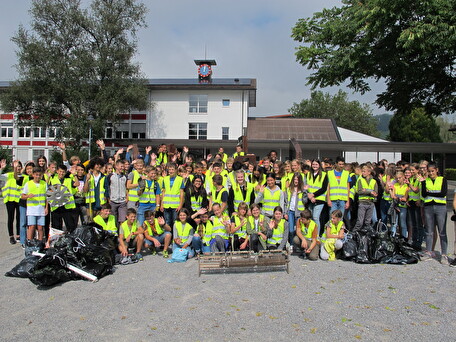 Die Abfall sammelnden Schülerinnen und Schüler mit dem gefundenen Klavierteil im Vordergrund.