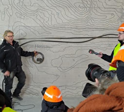 Ab dem 3. April wieder offen und neu gestaltet: Die Zentralunterführung am Bahnhof Herisau, in der am Montag eine Medienbegehung stattfand. Franz Koster, Senior Chef der Schmiede Koster GmbH erklärt, wie sein Team die Orts-Plaketten anbringt.