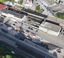 Das Drohnenfoto zeigt die Baustelle bei der östlichen Unterführung. Orange die Markierung für die umzulegende Güterstrasse, in der Bildmitte beim Kran der neue Liftschacht. 