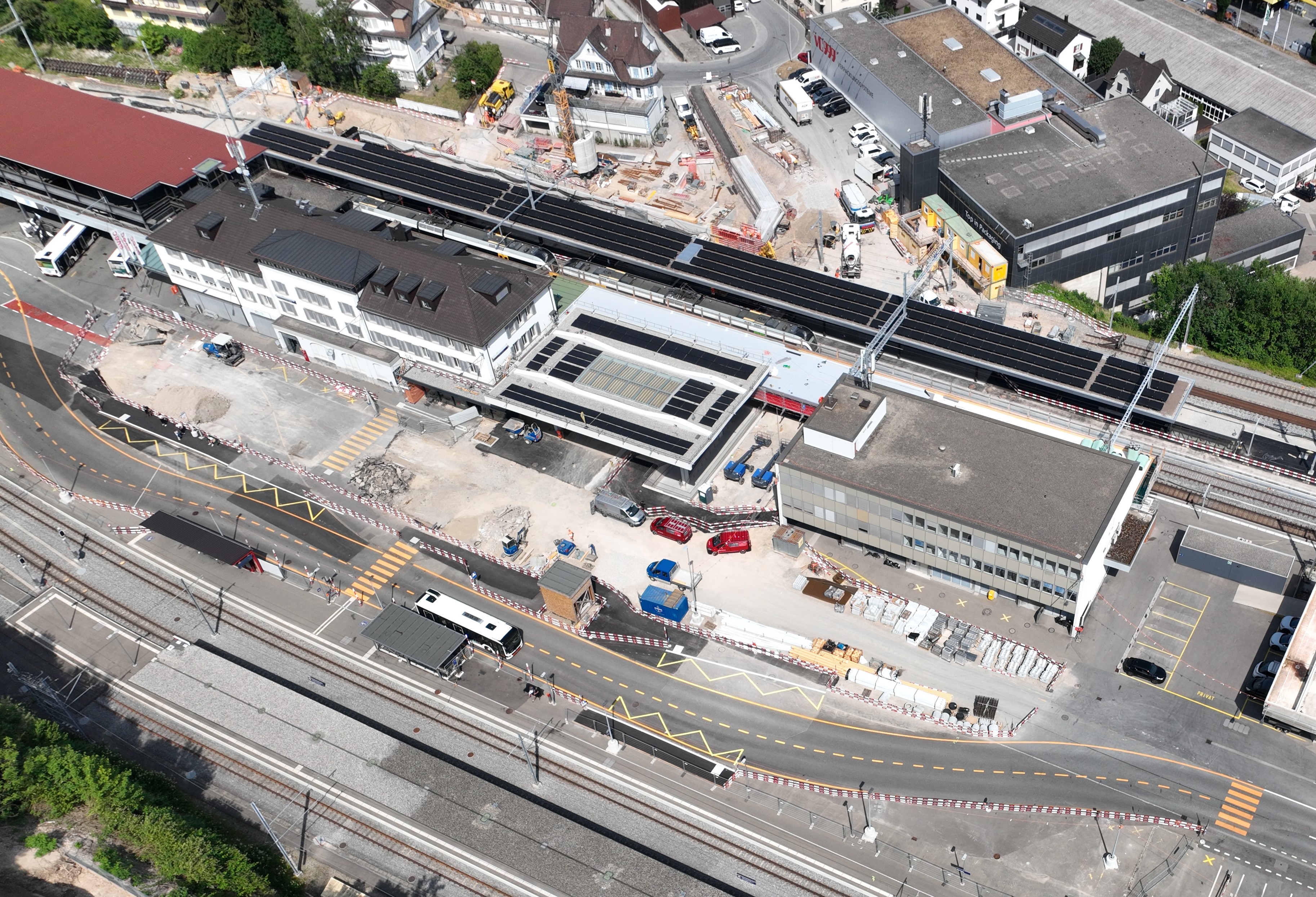 Vor dem Zentraldach laufen die Vorbereitungen für die Platzierung der künftigen Bodenplatten des Zentralplatzes. Auf den SOB-Perrondächern sind Photovoltaik-Module platziert.