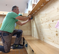 Hanspeter Ehrbar vor einer massangefertigten, dank Rollen verschiebbaren Garderobe im Kindergarten Bleiche.