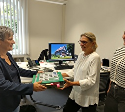 Legende: Maya Küng (links) übergibt symbolisch das Fotoarchiv ihres Mannes an die Archivarinnen der Gemeinde Gerda Leipold (Mitte) und Selina Sprecher (rechts).