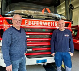 Beni Geel, Abteilungsleiter Technische Dienste, und Joe Gwerder, Gerätewart Feuerwehr, vor einem Tanklöschfahrzeug im Feuerwehrdepot.