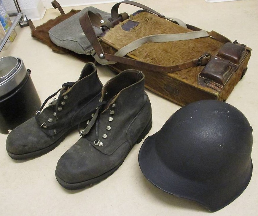 Militärhelm, -schuhe und Tornister aus dem Zweiten Weltkrieg