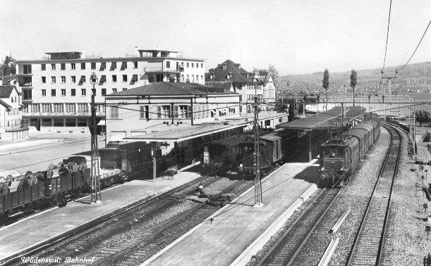 Der neue Bahnhof Wädenswil wurde am 29. Oktober 1932 eingeweiht. Das Bild zeigt den neuen Bahnhof mit den erweiterten Geleisanlagen und im Hintergrund den Kronenblock (erstes grosses Flachdach). Links vom Kronenblock ist die Bäckerei Ammann zu sehen.