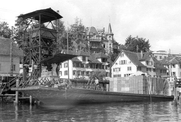 Auf dem Bild ist die Verladeeinrichtung für Harassen zu sehen. Die Harassen wurden mit einem Förderband unter der Seestrasse von der Brauerei zum Hafen befördert. Im Hintergrund die Brauerei-Villa von 1896, die heute noch steht.