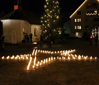 Weihnachtliche Stimmung auf dem Dorfplatz mit Kerzenschein