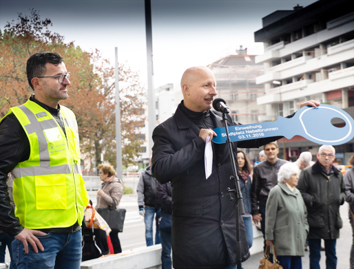 Stadtrat Stefano Kunz übergibt Carlos Pighin, Bereichsleiter Gas- und Wasserversorgung, den symbolischen Schlüssel zum Brunnen.
