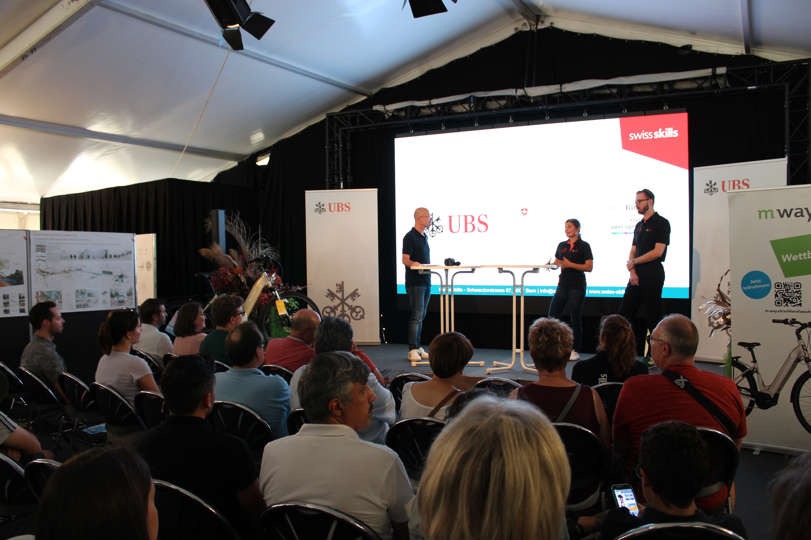 Die SwissSkills-Champions Carla Calderari, Kosmetikerin EFZ, und Damien Ulrich, Gebäudetechnikplaner Heizung EFZ, während der Podiumsdiskussion mit Lehrbetriebsberater Peter Heiniger.