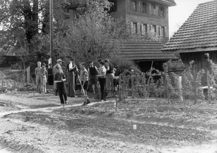 Lehrer Albert Elmiger mit Schülern im Schulgarten beim alten Pfarrhaus.