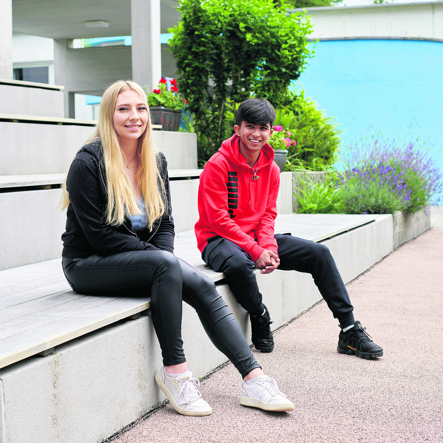 Zwei junge Erwachsene sitzen auf einer Bank