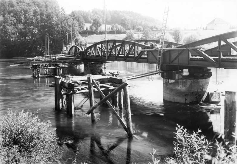 Hölzerne, mit Jochen verbundene Pfähle bildeten die provisorischen Stützen. Zwischen ihnen und den Pfeilern wurden Verschubbahnen mit Rollenzügen montiert (s. hinten, vorne fehlt die Konstruktion noch).