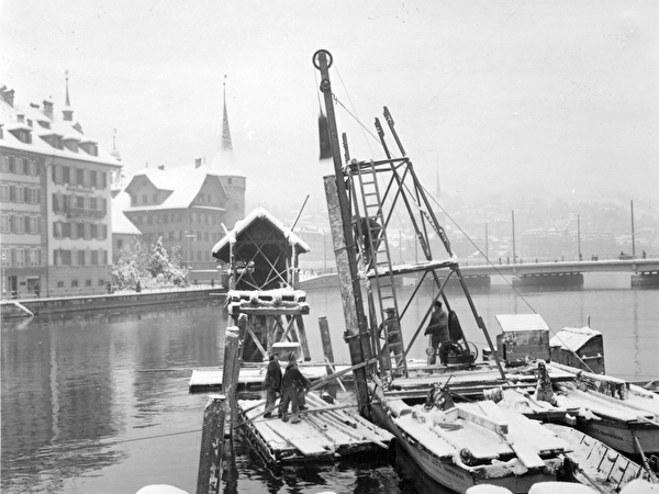 Schwarz-weiss-Foto, Einrammen eines Brückenfahls im Winter