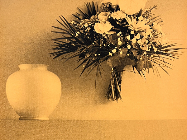 Vase und daneben ein in der Luft hängender Strauss