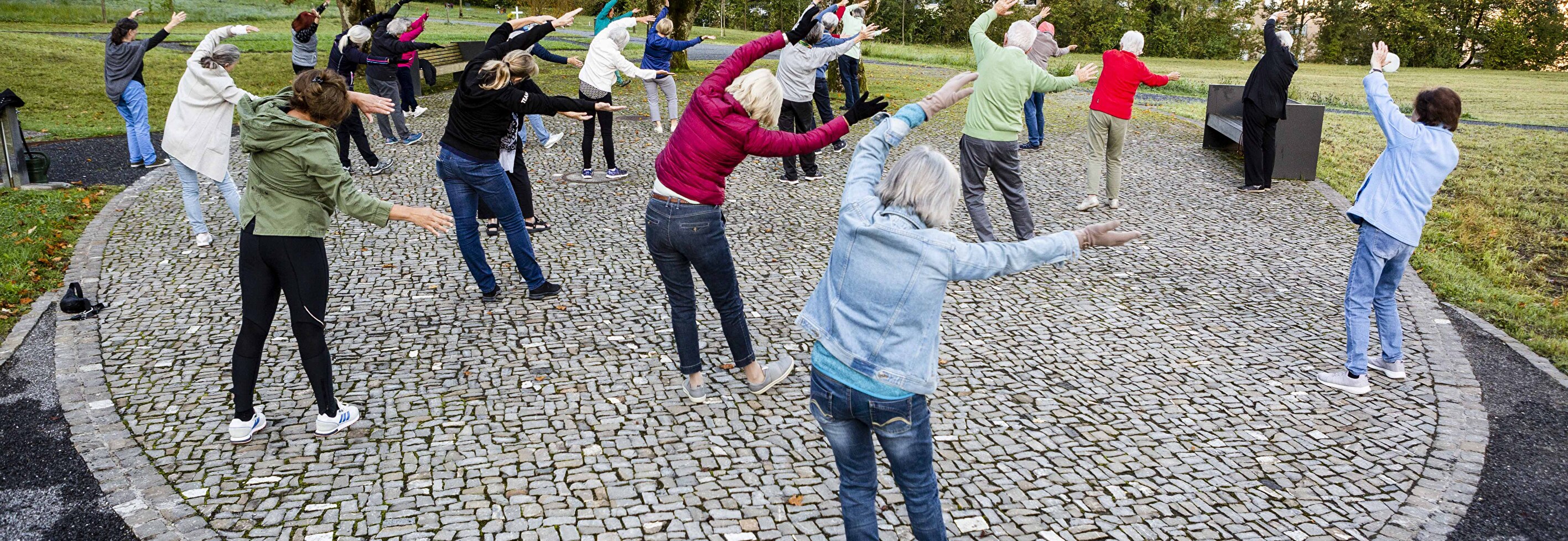 Gruppe praktiziert Qi Gong auf dem Waldfriedhof Staffeln