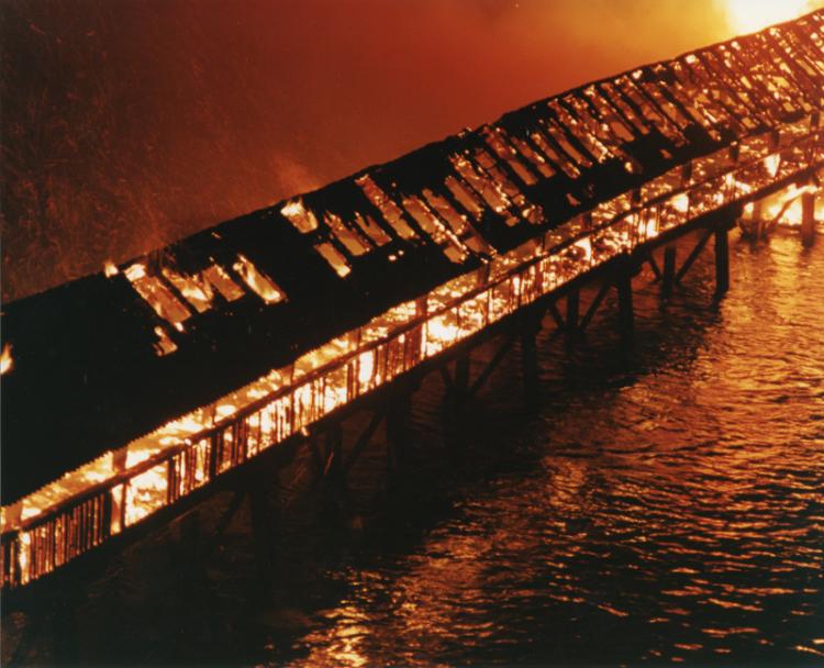 Das Feuer hat sich schon weit über die Brücke vorgefressen.