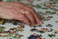 Hand am Puzzle spielen