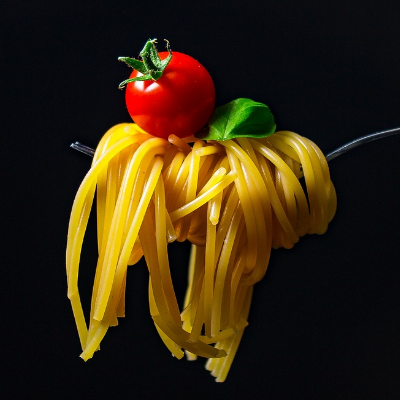 Spaghetti auf Gabel mit Tomate und Basilikum