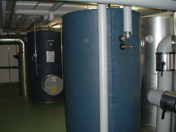 Die beiden Warmwasserspeicher. Ein dritter Speicher (nicht im Bild) nimmt die Energie von der Solaranlage auf (32 m2), die sich auf dem Flachdach der Turnhalle befindet.
