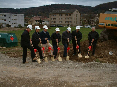Der grosse Spatenstich am 17. November 2004 mit der Bauherrschaft, dem Bankenvertreter, dem Bauleiter, dem Architekten und mit Behördenmitgliedern. Mitten im Dorf wird die "Wohnoase Unterfeld" in drei Baukörpern 70 moderne Wohnungen anbieten. Grosszügige Grünanlagen machen die neue Überbauung zu einer Wohnoase.