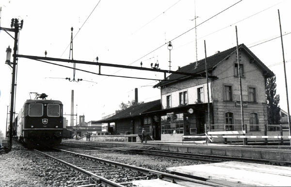 1976 - Bahnhof Niederglatt vor dem Ausbau
Auf Gleis 4 steht ein Kieszug mit einer Re 4/4. Im Vordergrund sind die eingebauten Hilfsbrücken für die Erstellung der Personenunterführung sichtbar.
