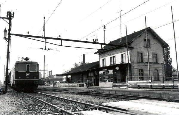 1976 - Bahnhof Niederglatt vor dem Ausbau
Auf Gleis 4 steht ein Kieszug mit einer Re 4/4. Im Vordergrund sind die eingebauten Hilfsbrücken für die Erstellung der Personenunterführung sichtbar.