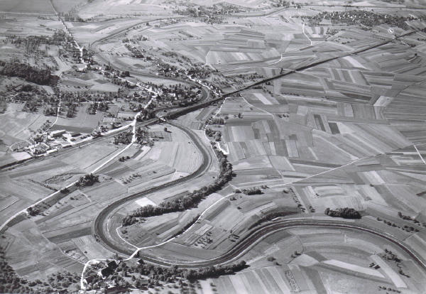 Foto 6. Juni 1950
Vier Elemente prägen diese Luftaufnahme: Da sind einmal die Felder, die sich mit einem Parkettboden vergleichen lassen. Das <b>Ackerland</b> in der rechten Bildhälfte ist das älteste bebaute Land in unserer Gemeinde, denn es war, da leicht erhöht, von jeher vor Überschwemmungen sicher.
Zwei Linien beherrschen zudem das Bild: Die <b>Glatt</b> und die <b>Bahnlinie</b> mit Bahnhof am linken Bildrand.
Als viertes Element, die <b>Dörfer</b>: u.l. Hofstetten, oben v.l.n.r. Oberhöri, Niederhöri und Endhöri.

