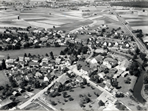 Foto ca. 1962
Die Aufnahme zeigt wie die Sonnenbergstrasse noch direkt in den Löwenplatz einmündete. Am Rande der Grafschaft, an der Bachenbülacherstrasse, werden vier neue Häuser gebaut. Der alleinstehende Silo, oben links, wurde 1962 erstellt, bevor die Siedlung Ernst Müller, im Saali 1963/64 fertig gebaut wurde.