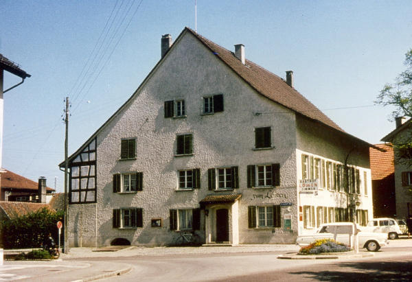 Aufnahme 1966: Welch ein "Fortschritt"!
Die ehemals belebenden Details sind entfernt oder verputzt worden. Das Dach wirkt mit den neuen Ziegeln schwer und fremd.
Den negativen Eindruck vermag auch die Freilegung des Riegels am Anbau nicht zu beseitigen. Sollte dem für unsere Gemeinde wichtigen und einmaligen Gebäude nicht möglichst wieder seine ursprüngliche Asstrahlung zurückgegeben werden?
(Text: Lo 1982)