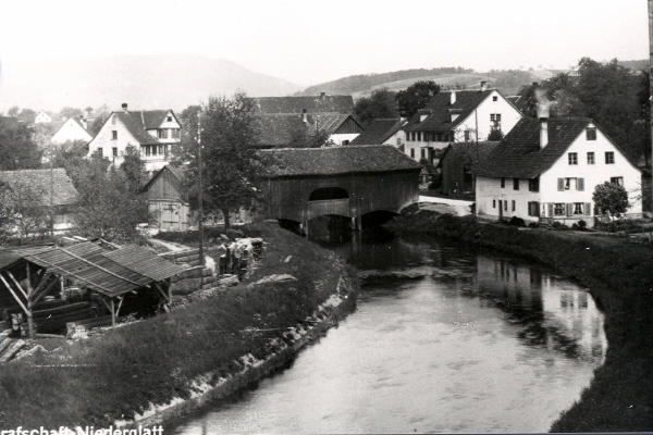 Die obere Holzbrücke wurde 1924 durch eine Betonbrücke ersetzt. Das Haus "Ringger" rechts neben der Brücke wurde im 1934, anlässlich einer Glattabsenkung abgebrochen.