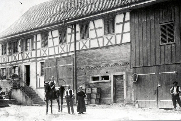 Baujahr vor 1842, Foto 1918
Joh. Hch. Moor (Vetter Heiri) mit Frau und Knabe auf Pferd.
<i>Das Haus liegt gegenüber dem Rest. Blauer Fasan (vorm. Metzgerhalle)</i>