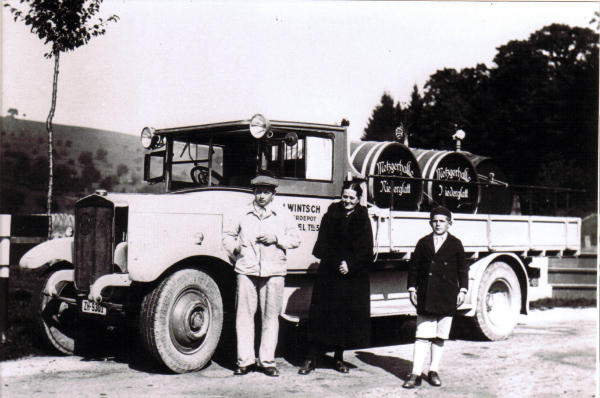 Foto 1935
Nachdem seit dem 1. Weltkrieg 1914/18 alle Reben aus dem Dorf verschwunden waren, mussten die Wirte den Wein auswärts kaufen. Der alljährliche Weintransport aus dem Klettgau führte Willi Wintsch vom Bierdepot Stadel, für die Metzgerhalle mit Wirtin Amalie Trachsel-Volkart, durch. Der Fassputzer-Bube Gottfried Moor, geb. 1922, durfte mitfahren.