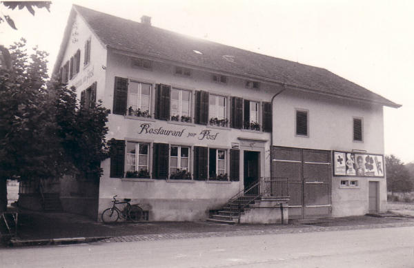 Foto 1934
Das Restaurant zur Post, an der Kaiserstuhlstrasse, war einst von 1873 bis 1895 auch gleichzeitig die 3. Poststelle in Niederglatt. Das Haus wurde später neu gebaut und darin befindet sich heute die Bar Lounge "Puls 29".
