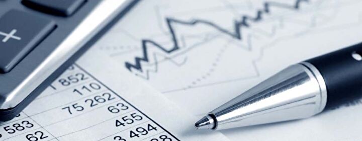 Symbolbild Finanzen mit Zahlen, Statistikausschnitt und Kugelschreiber