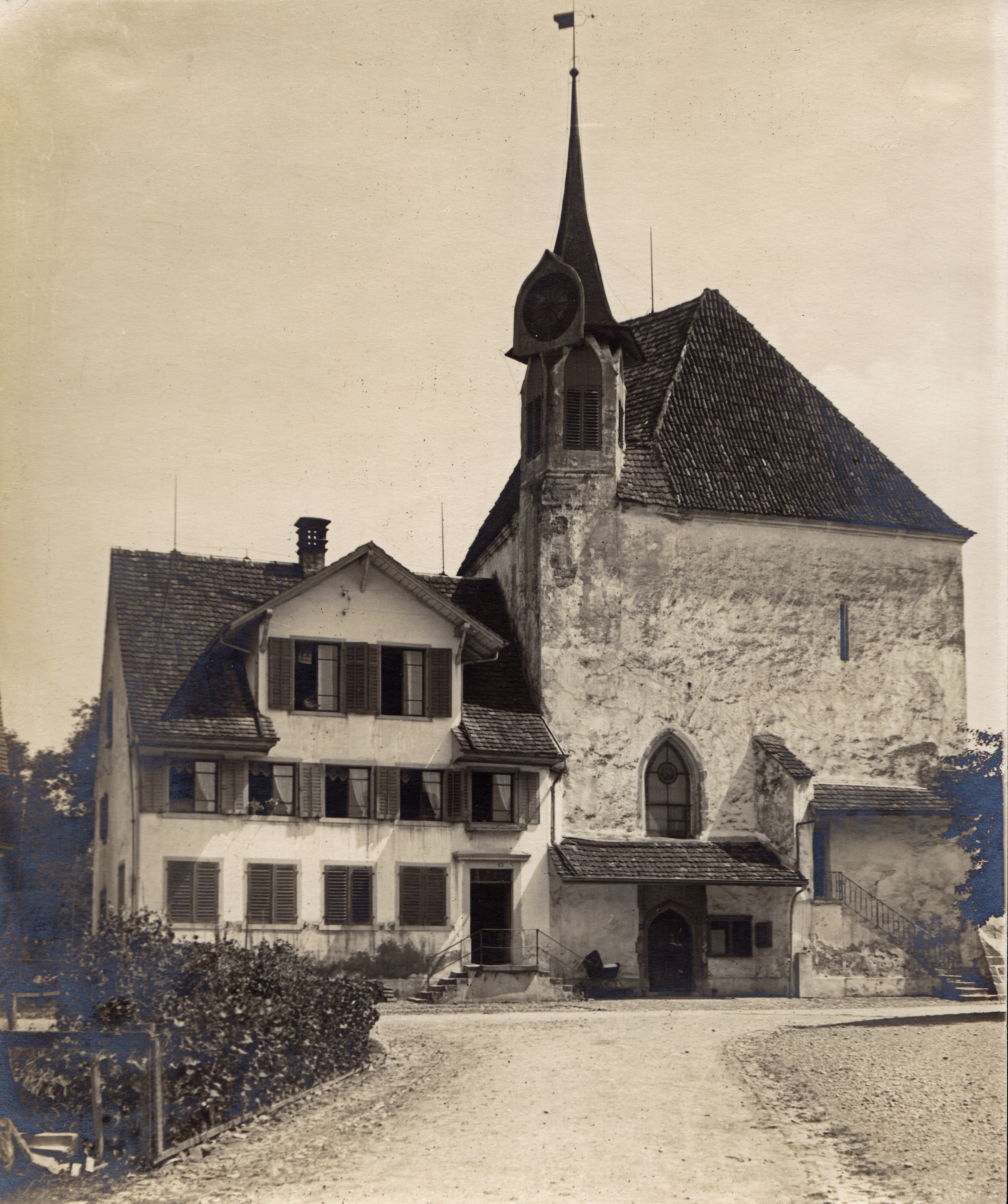Zuerst als einfacher Holzbau, dann als Steinbau direkt an die Kirche angebaut: 1895 wurde eine Dachlukarne eingebaut, damit der Lehrer ein sonniges Zimmer bewohnen konnte. Die Dachlukarne wurde später wieder entfernt.