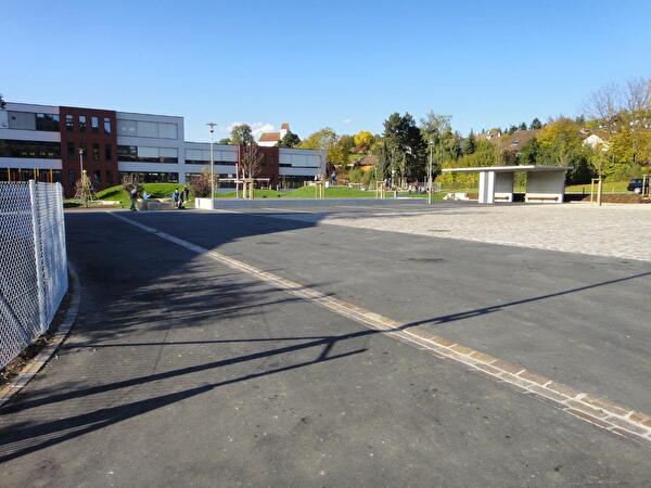Ansicht Dorfplatz mit Schulhaus im Hintergrund